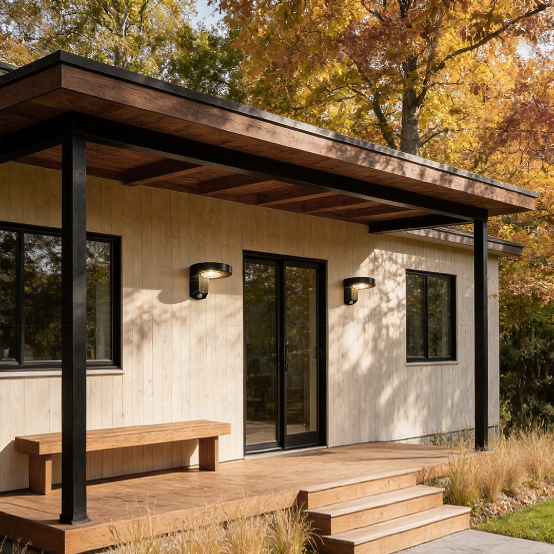 Outdoor solar lighting wall mount with a contemporary design, providing warm illumination near a porch.