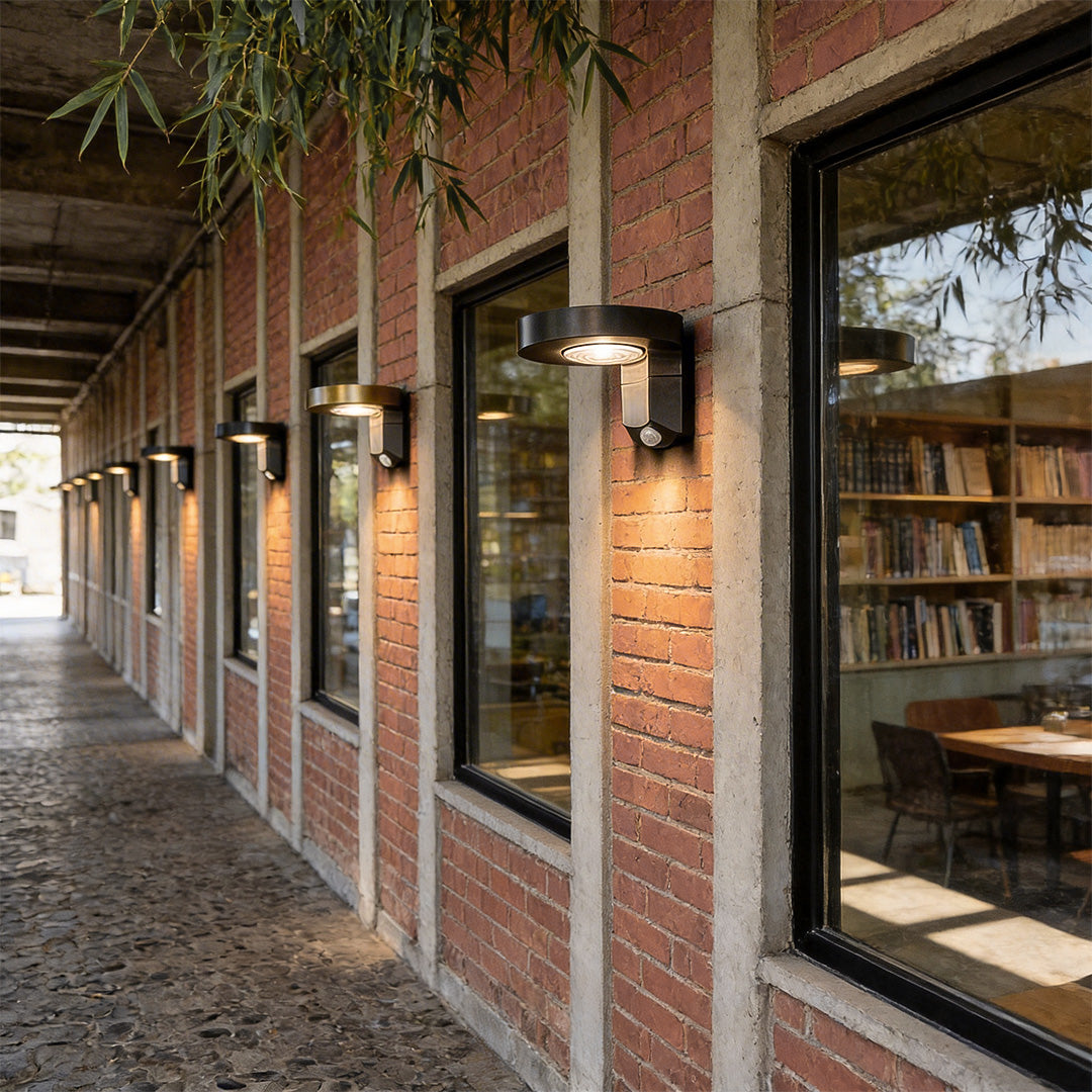 Outdoor solar lighting wall mount with a modern design, mounted along a brick building.