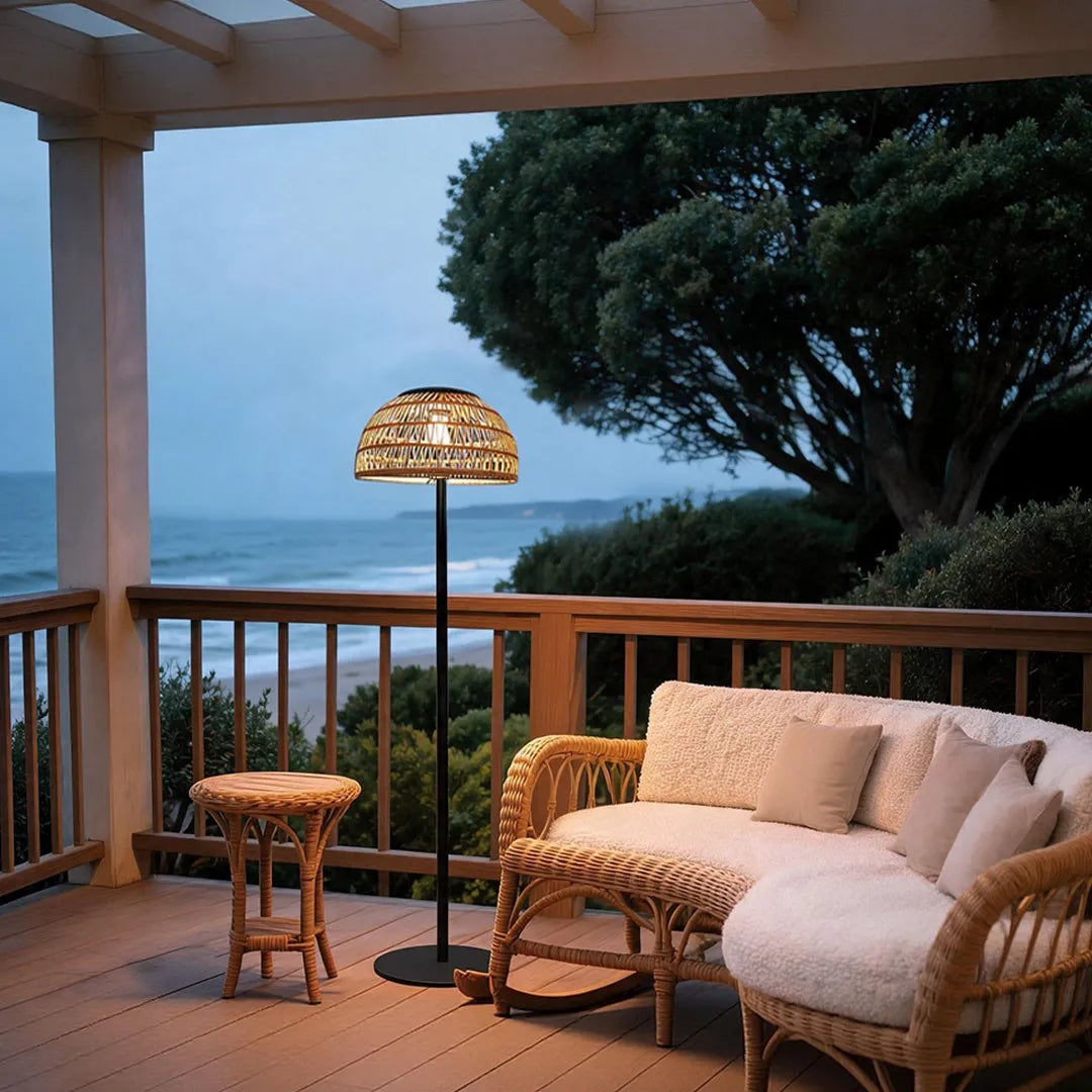 Outdoor solar pendant light placed on a patio with a woven shade and ambient landscape lighting.