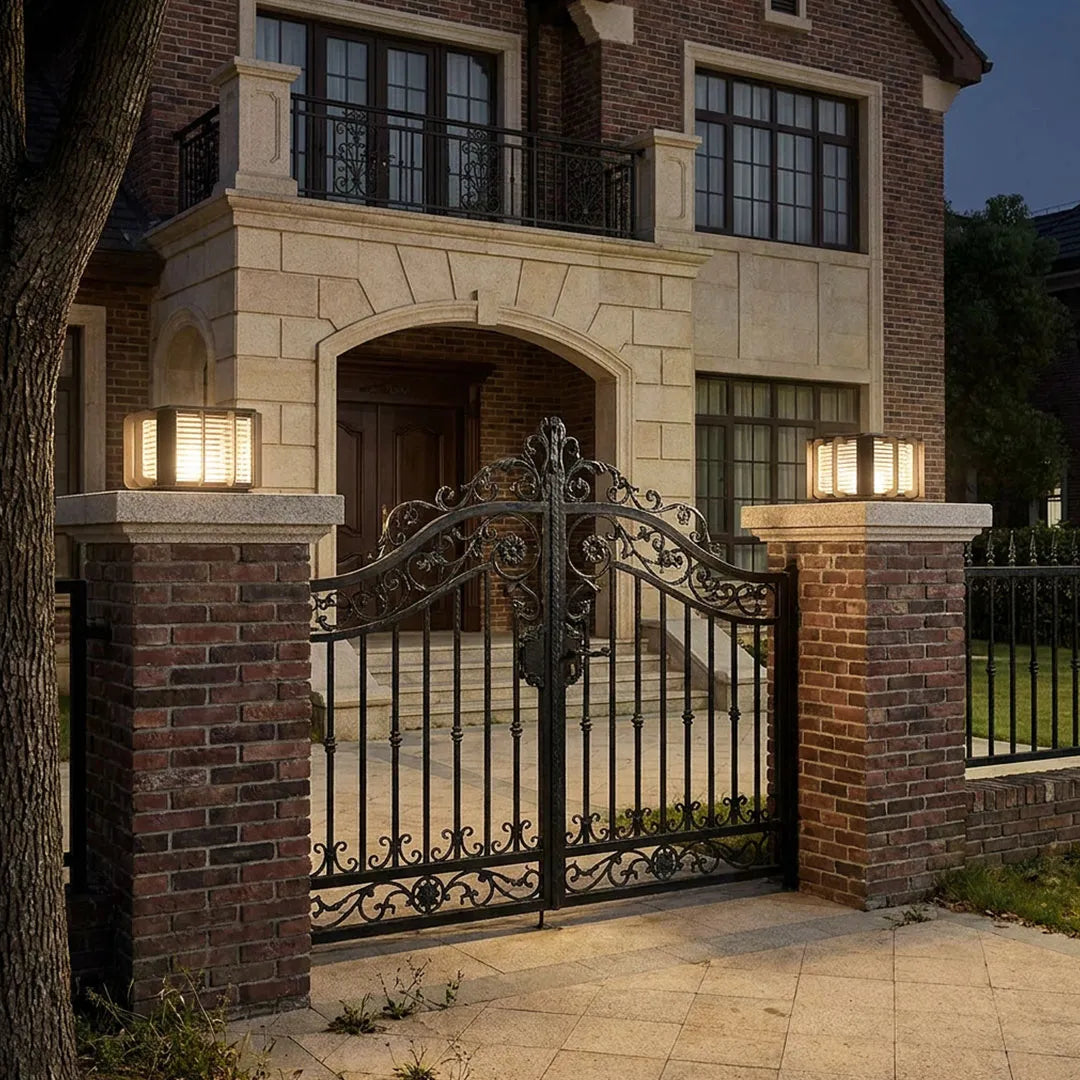 Outdoor solar pillar lights mounted beside a modern home entrance with warm decorative lighting.