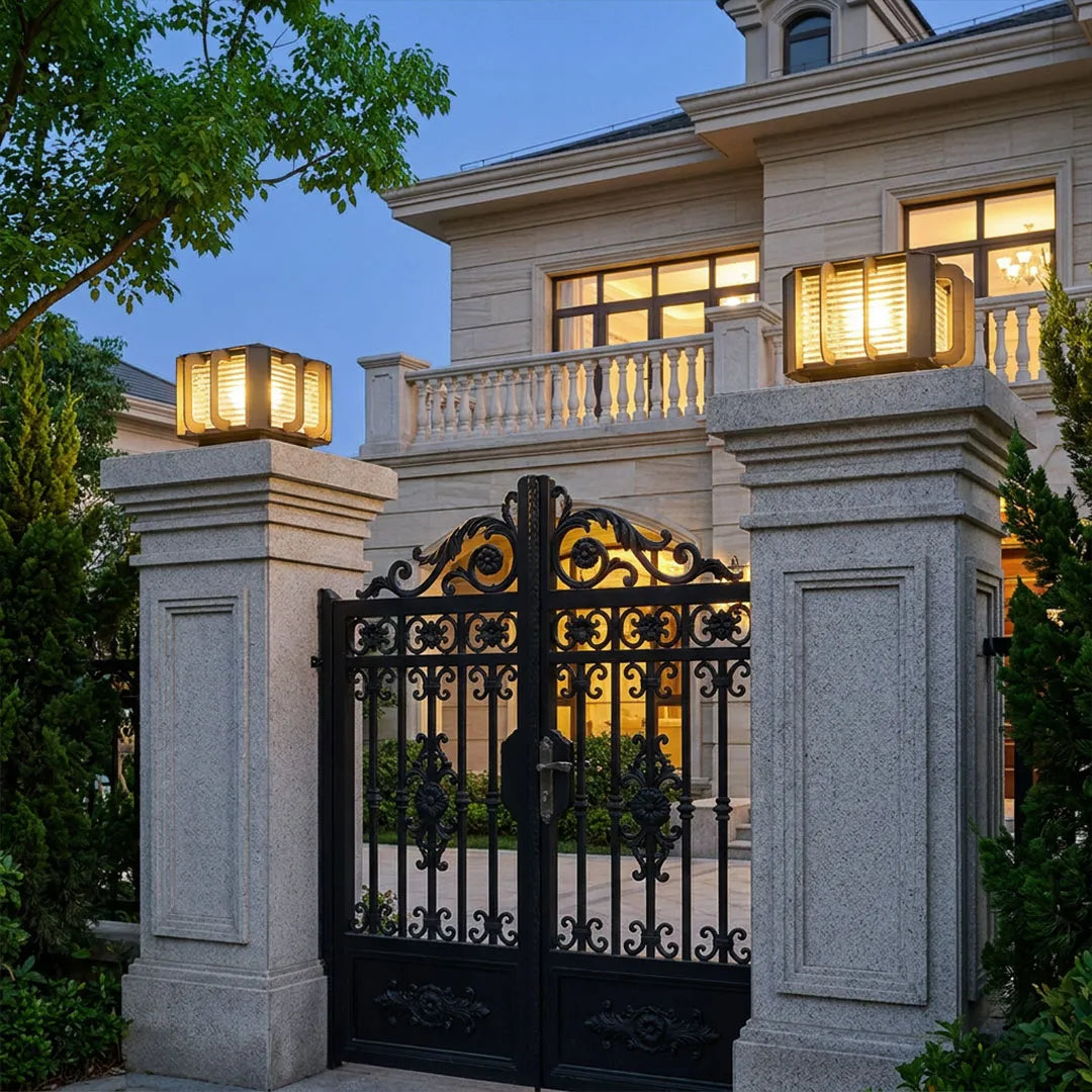 Outdoor solar pillar lights mounted on entrance gate columns creating warm exterior lighting.