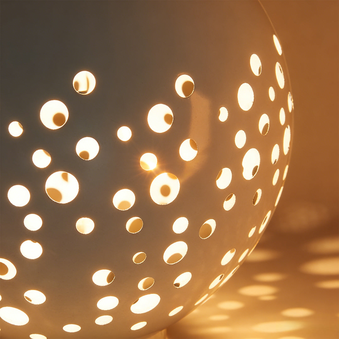 Outdoor sphere light with a close-up of its perforated pattern and glowing effect.