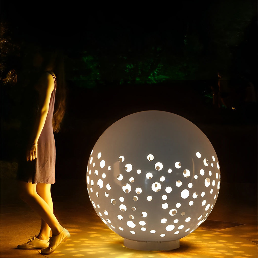 Outdoor sphere light with a sleek design, installed along a garden walkway.