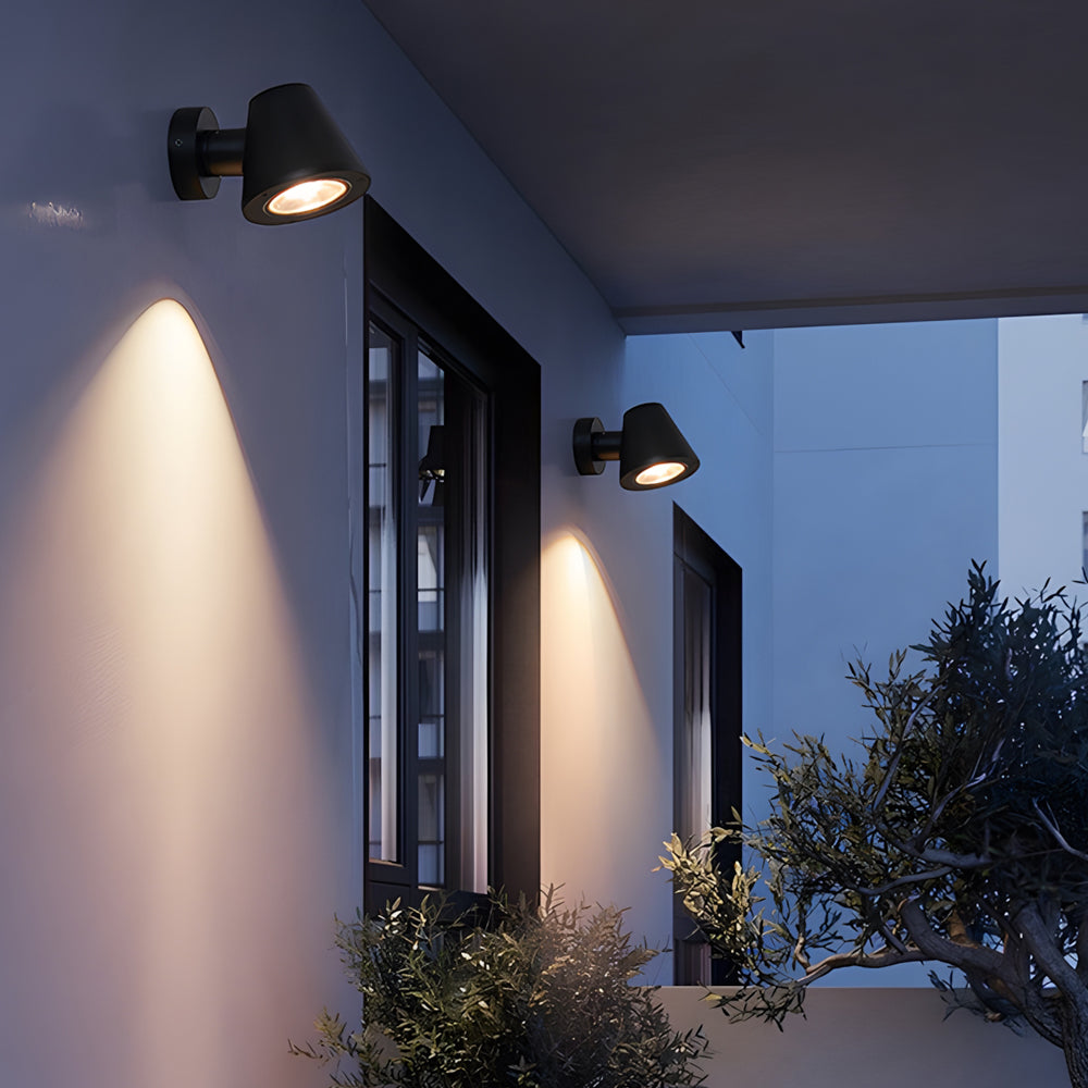 Modern outdoor spotlights illuminating contemporary building facade with warm directional lighting at dusk