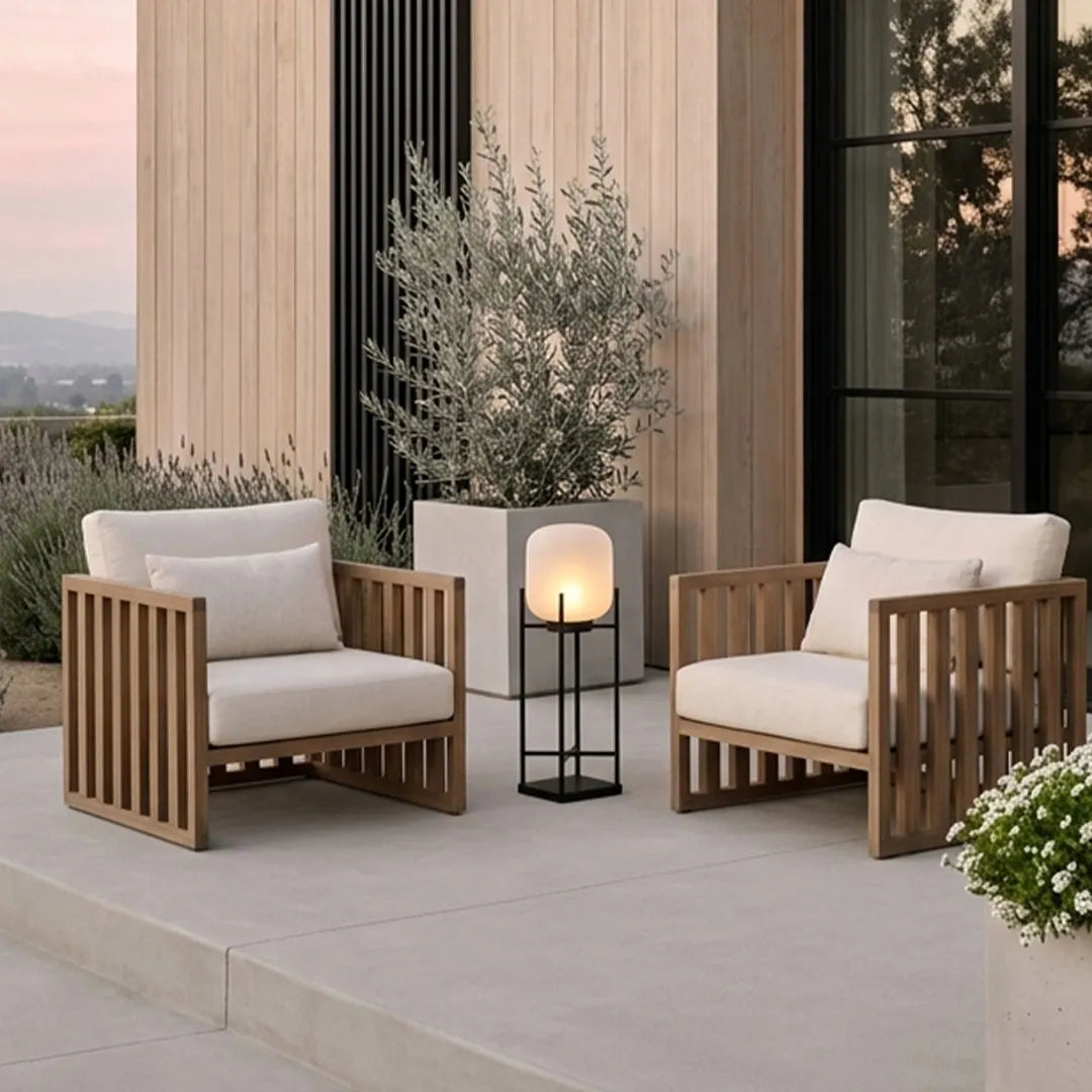 Outdoor standing light placed beside modern lounge chairs on a contemporary patio with wood accents