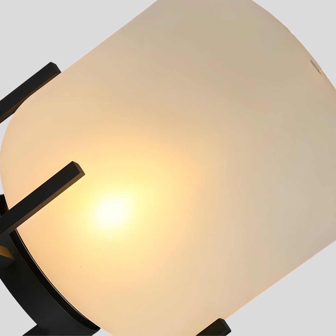 Outdoor standing light with frosted shade and black frame beside pool and lounge chairs.