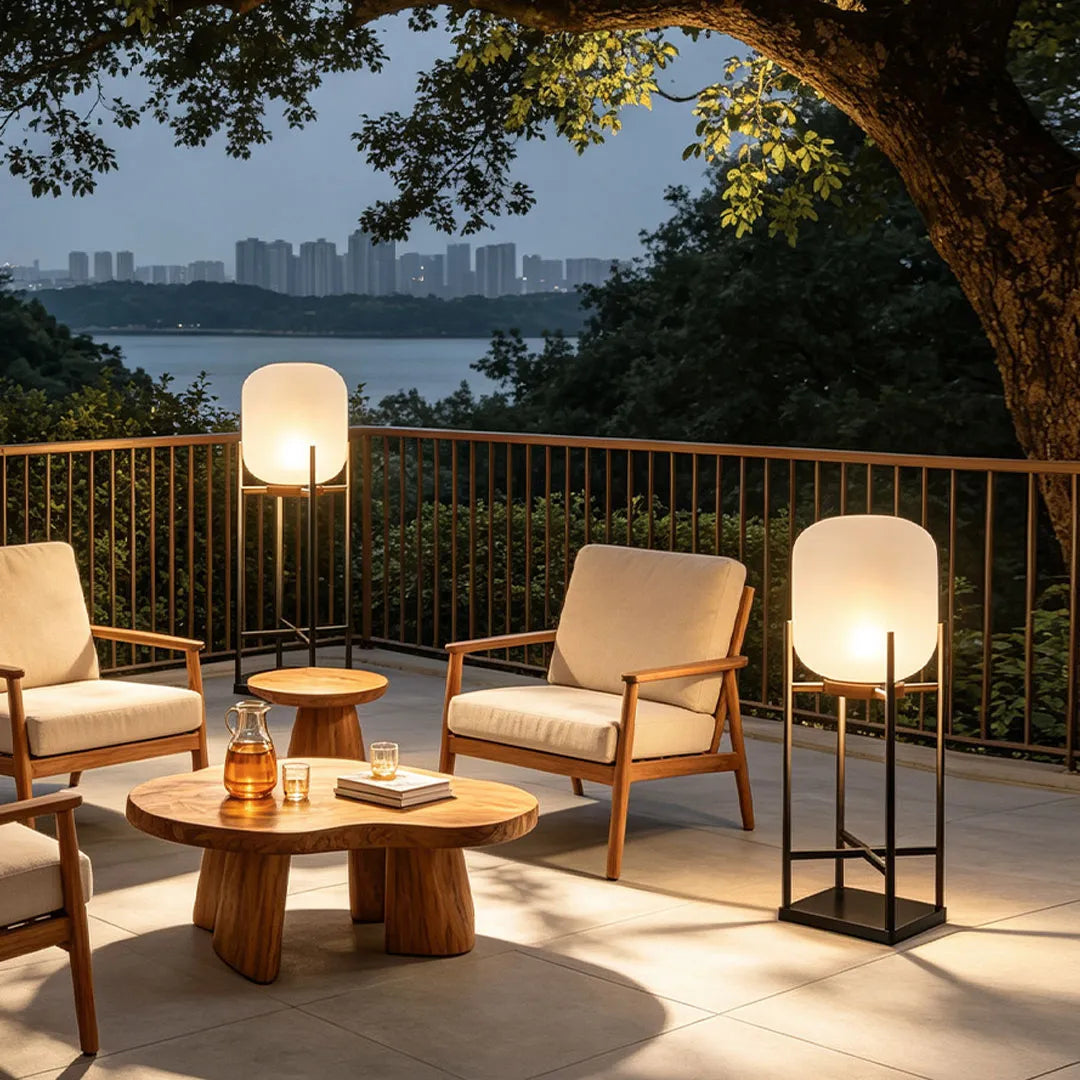 Outdoor standing lights arranged around a deck seating area with a scenic water view at dusk.