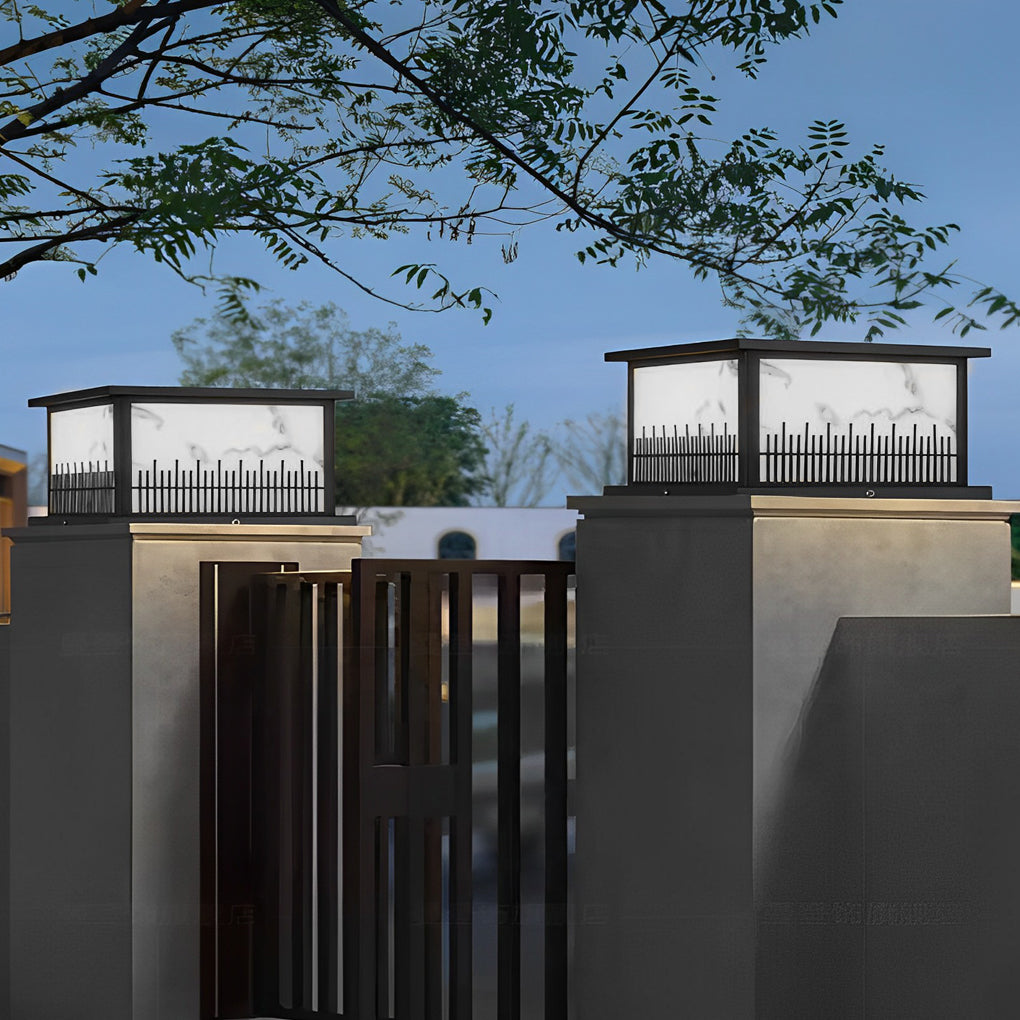 Outdoor stone pillar lights with a decorative fence pattern, adding charm to the front yard.