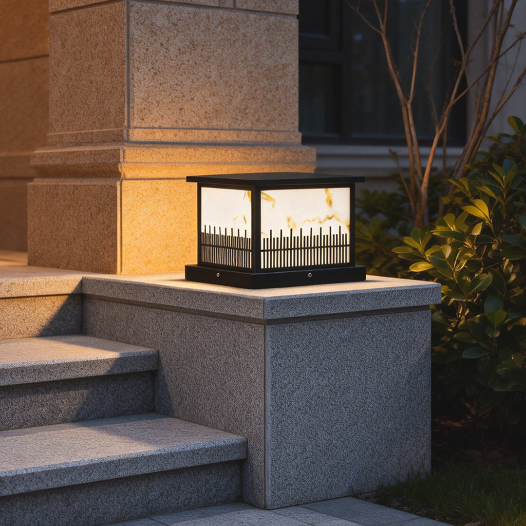 Outdoor stone pillar lights illuminating a set of stone steps, adding elegance to the garden entrance.