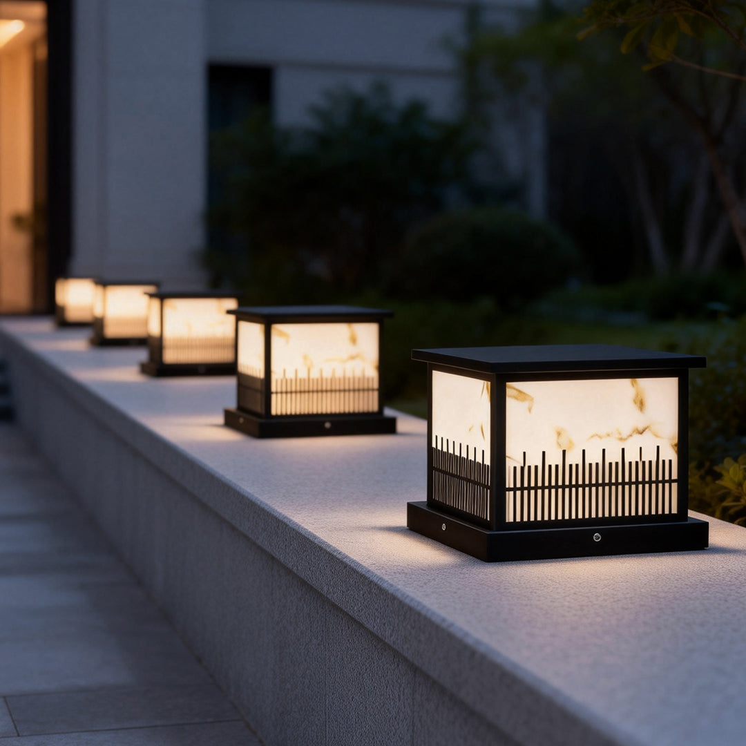 Outdoor stone pillar lights casting warm light along a pathway, enhancing the outdoor ambiance.