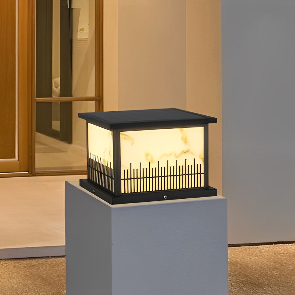 Outdoor stone pillar lights mounted on a white pillar, providing soft illumination for a modern driveway.