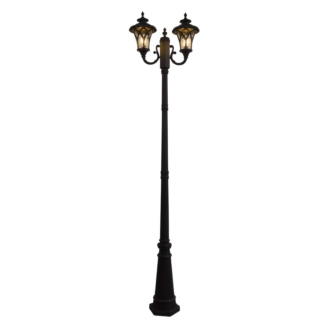 Outdoor street light with a triple lamp design, mounted on a decorative pole.