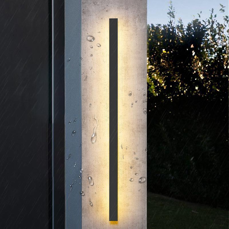 Outdoor strip wall light casting a gentle vertical glow on a concrete wall.