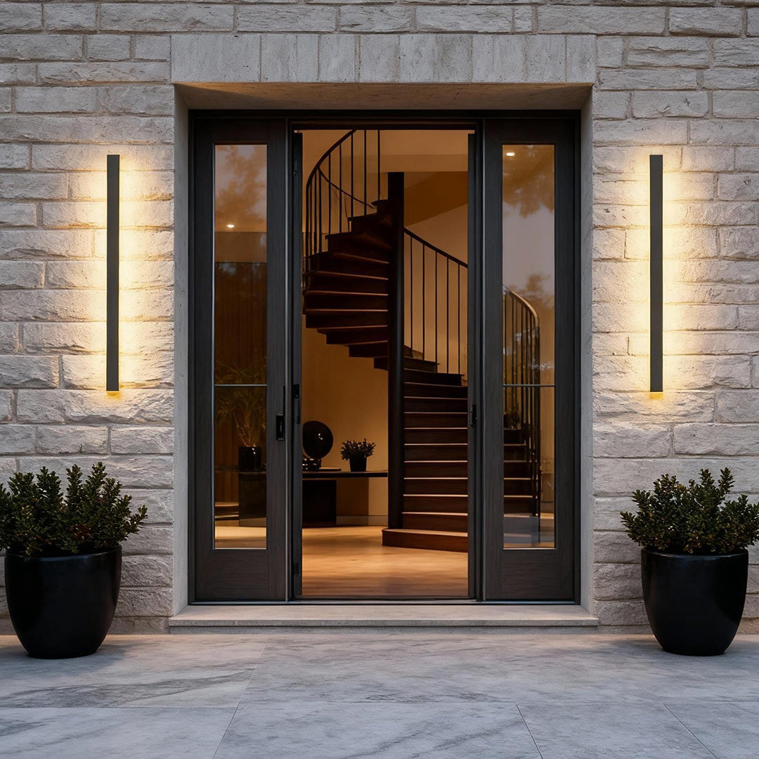 Outdoor strip wall light illuminating a modern house entrance with vertical warm glow.