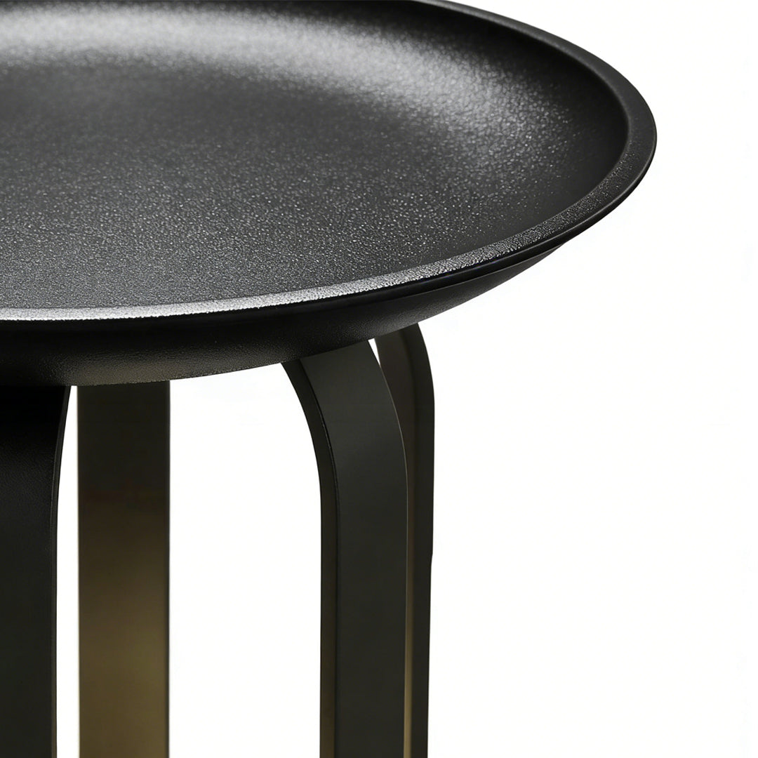 Outdoor tray floor lamp with a black finish, providing warm illumination near a garden.