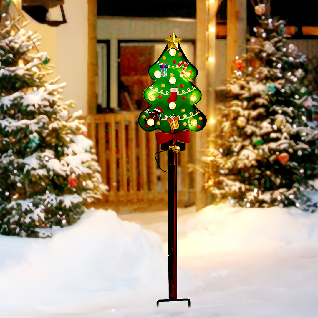 Illuminated Christmas tree ground stake for Christmas lights placed outdoors in snowy holiday scenery.