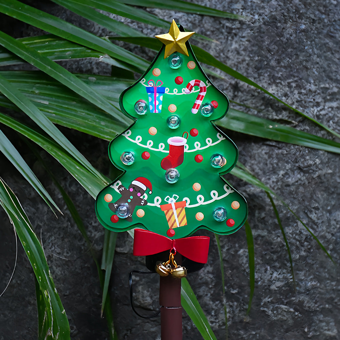 Illuminated Christmas tree ground stake for Christmas lights placed outdoors in snowy holiday scenery.