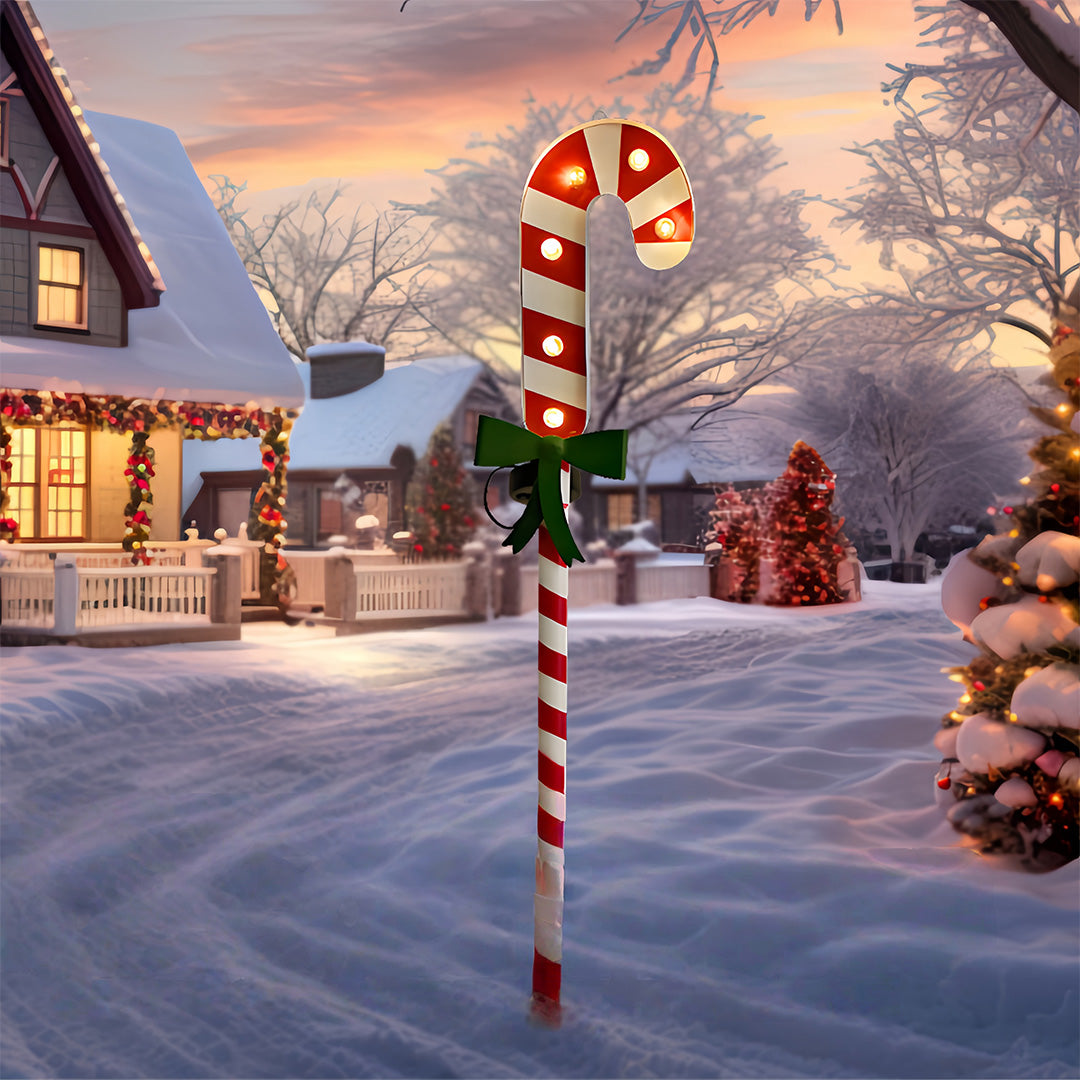 Illuminated Christmas tree ground stake for Christmas lights placed outdoors in snowy holiday scenery.