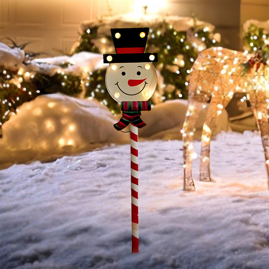Illuminated Christmas tree ground stake for Christmas lights placed outdoors in snowy holiday scenery.