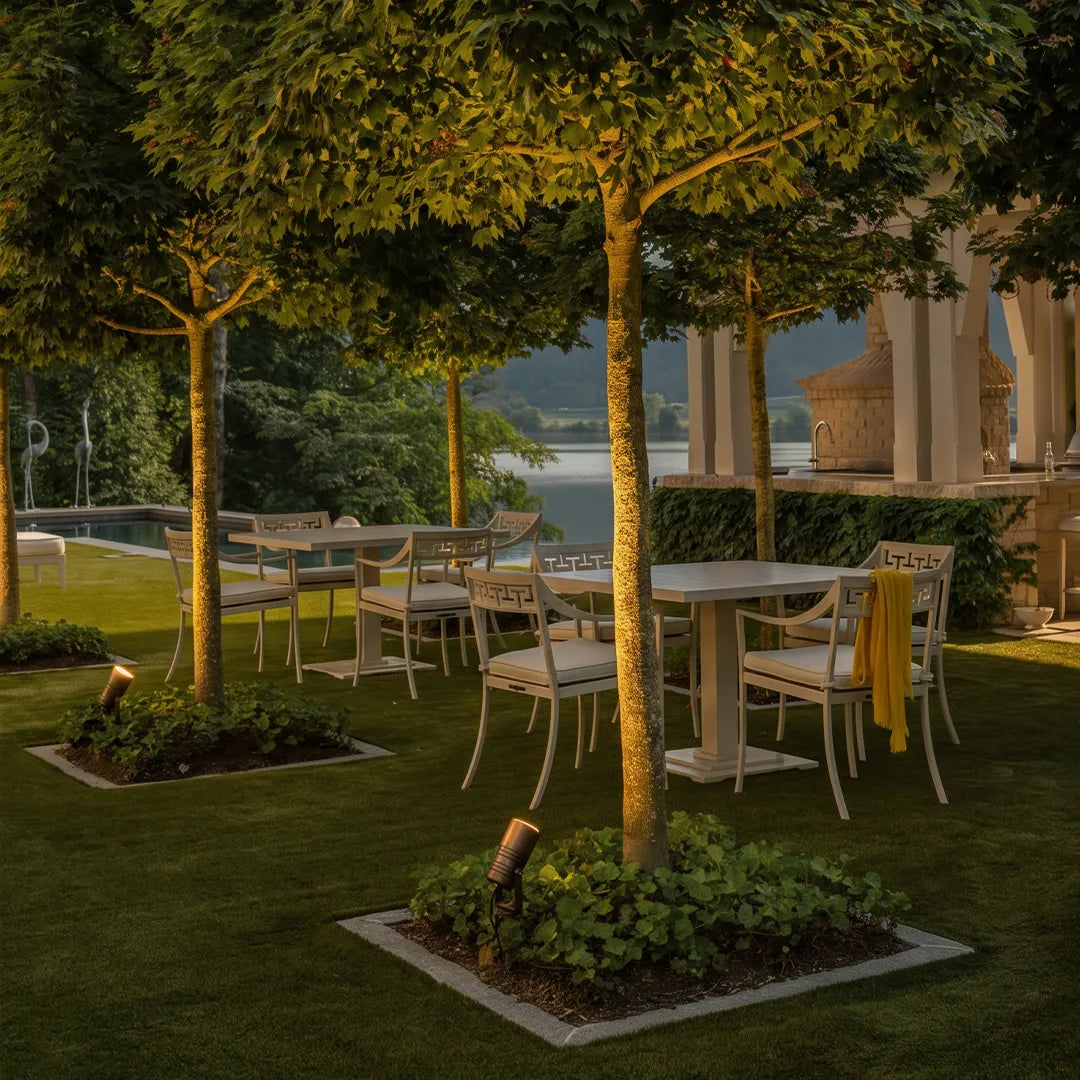 Outdoor tree uplighting with landscape spotlights beside garden dining area