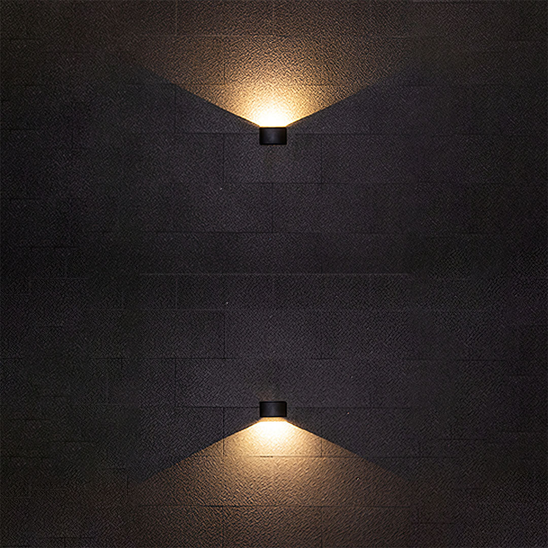 Outdoor up down wall light with triangular light distribution on dark textured wall