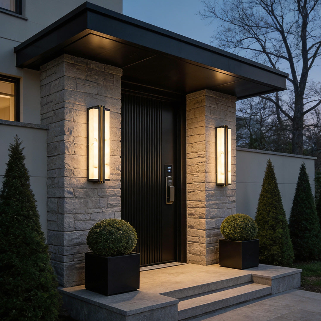 Outdoor vertical wall light mounted on stone porch entrance creating a modern architectural lighting effect.
