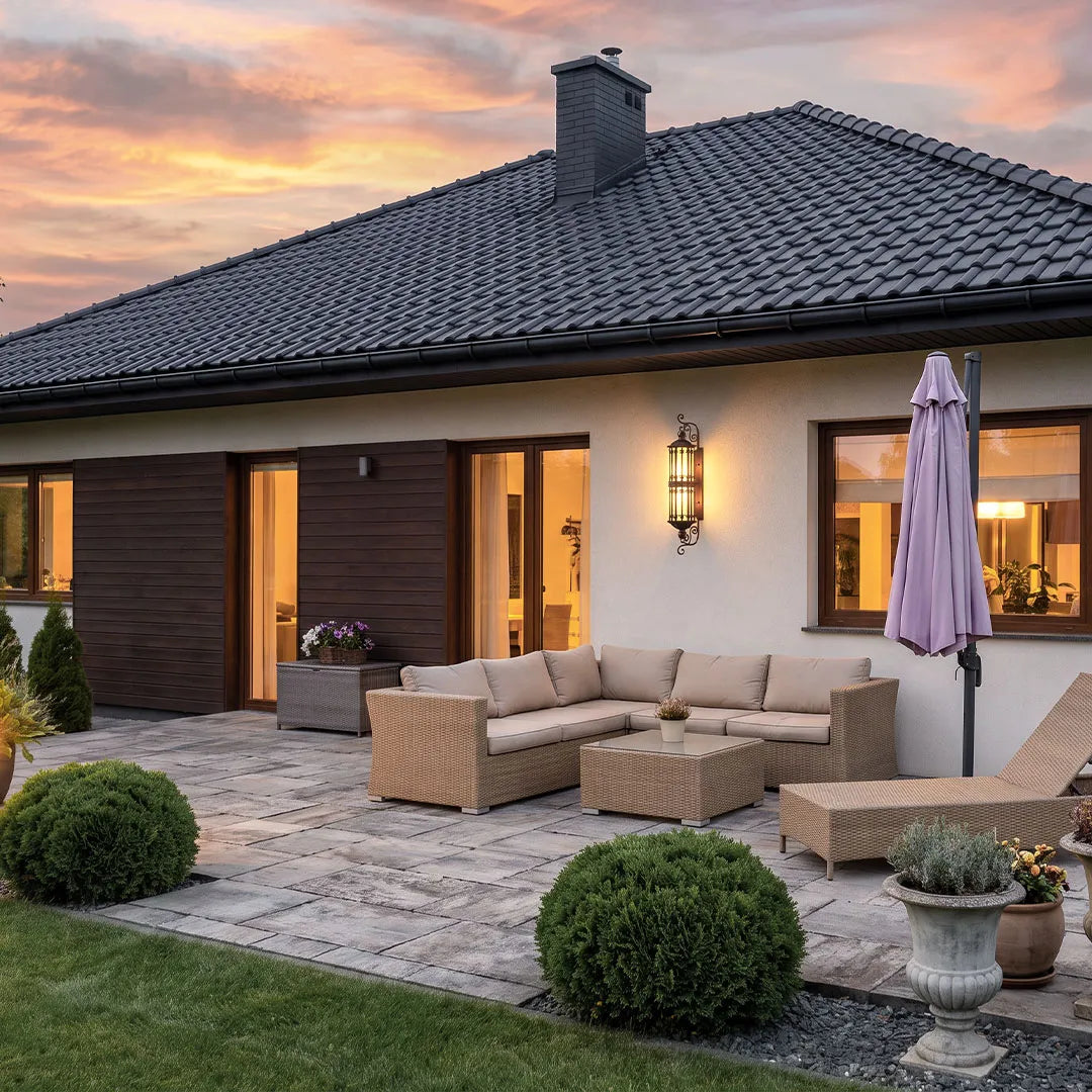 Vintage wall sconce lighting illuminating an outdoor seating area with a warm bronze lantern design.