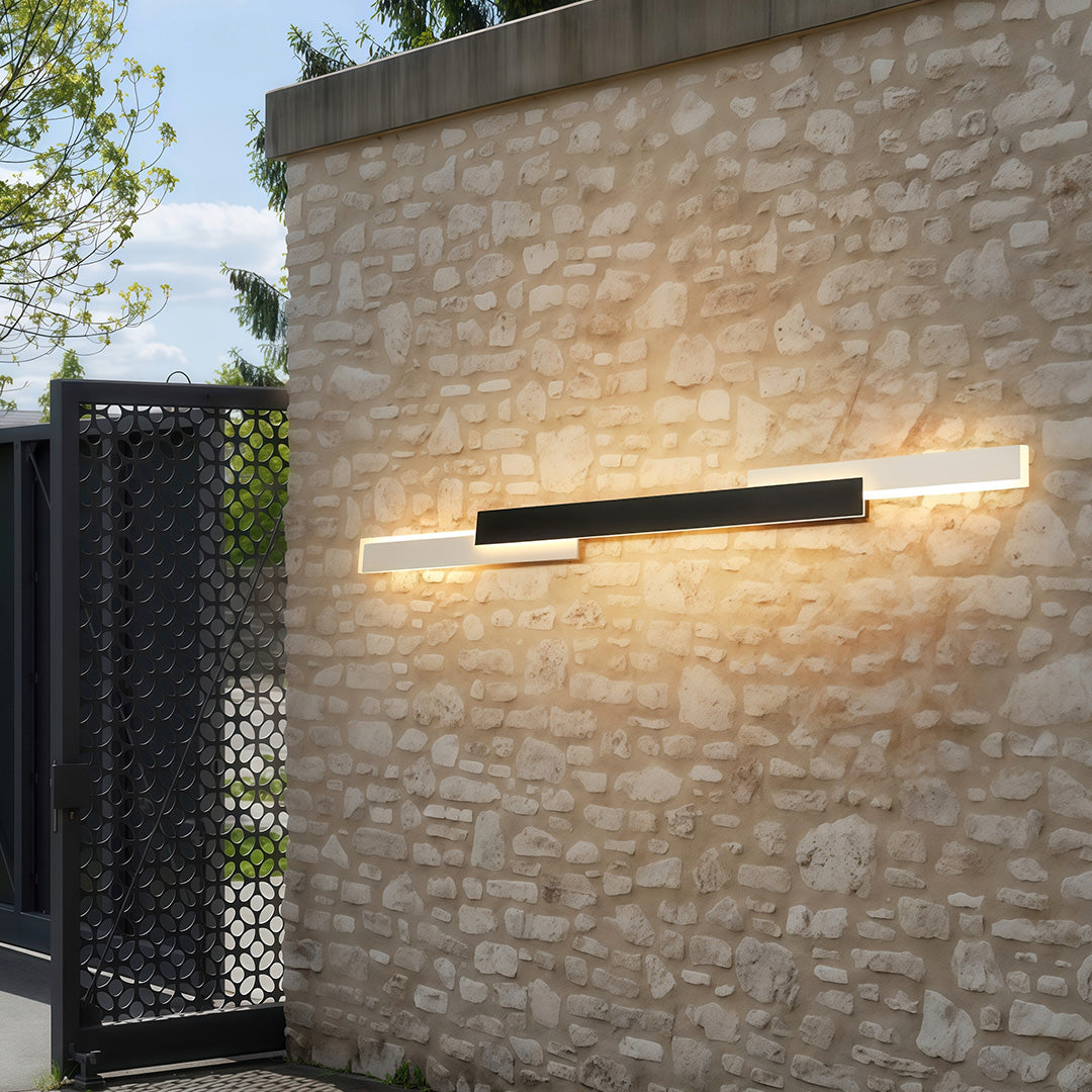 Outdoor light fixtures wall mount creating warm glow on brick textured exterior wall