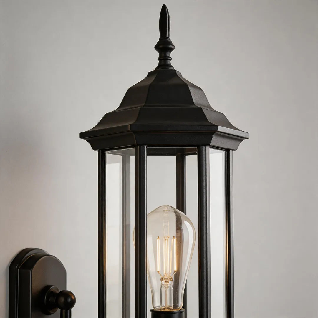 Outdoor wall lantern light product image with black finish, clear glass shade, and exposed bulb.