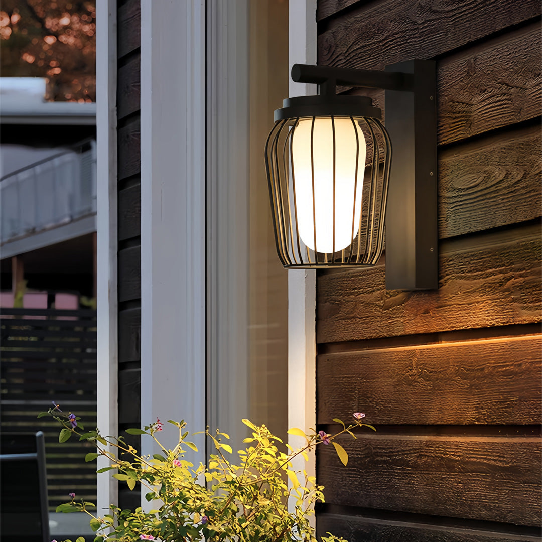 Outdoor wall lantern sconce illuminating a stone exterior wall, showcasing warm ambient lighting in a modern home setting.