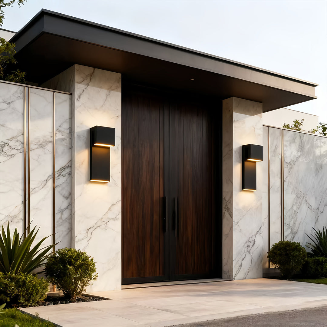 pair of industrial outdoor wall lights framing modern entryway with soft warm glow