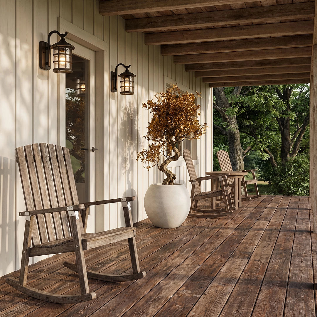 Outdoor wall light lantern adding warm light to a covered porch with a rocking chair and wood deck.
