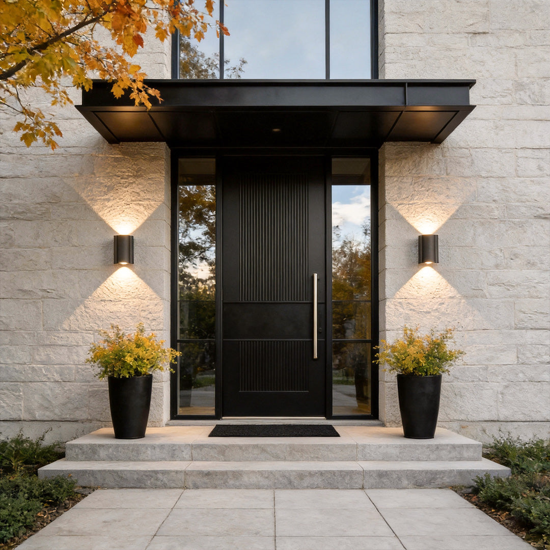 Outdoor wall light up down illuminating a modern house entrance with warm directional glow.