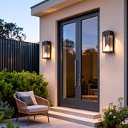 Outdoor wall lighting ideas flanking contemporary entryway with pink stucco walls and modern architectural elements