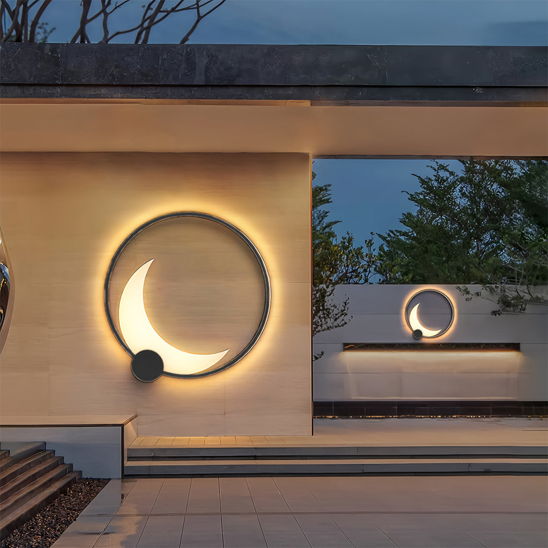 Decorative outdoor wall lights installed on modern building facade at dusk with landscaping