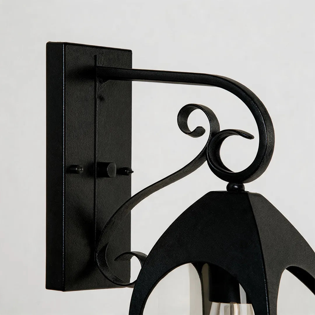 Outdoor wall mount lights detail view showing the black metal wall plate and decorative curved mounting arm.