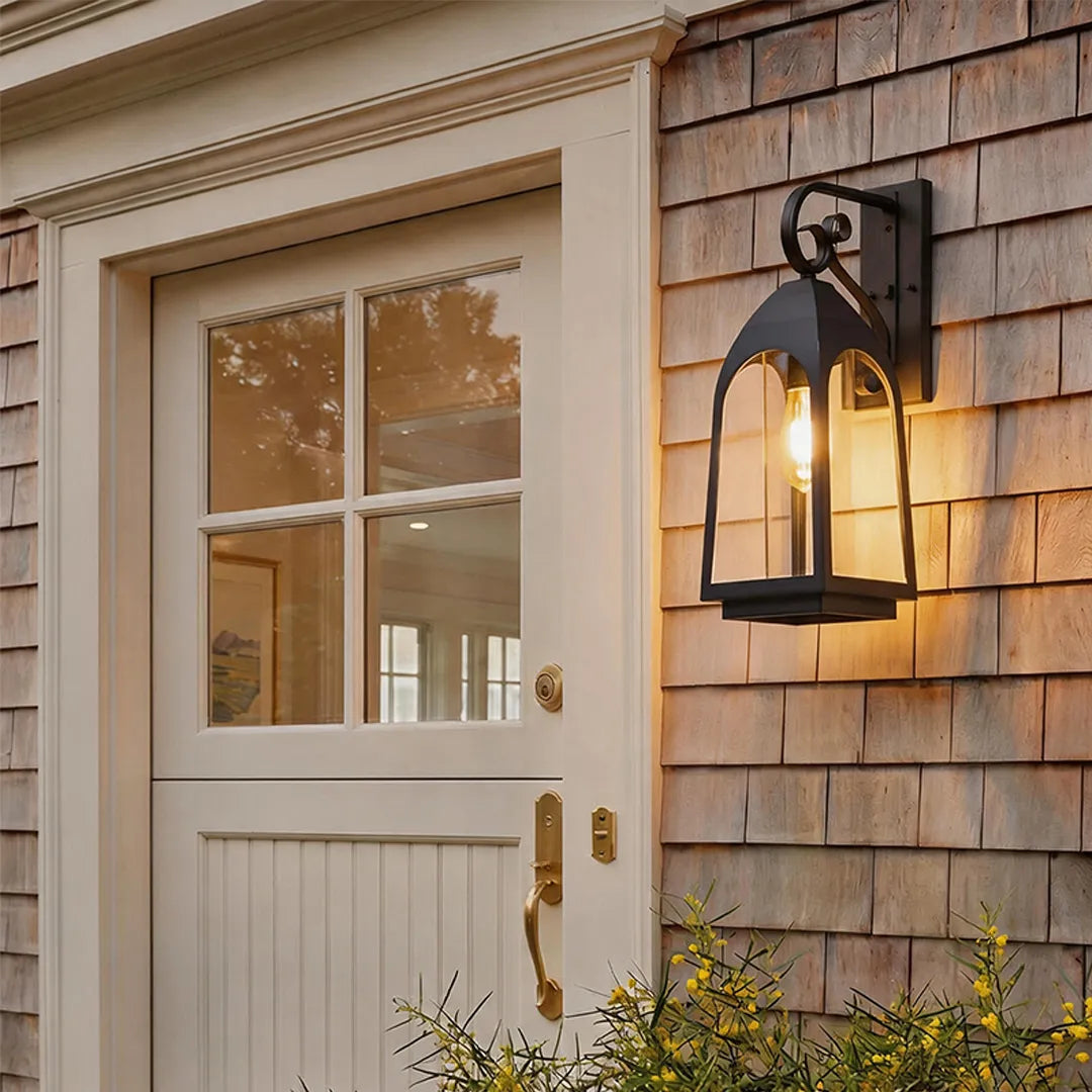 Outdoor wall mount lights on a wood shingle exterior beside a glass-paneled door.