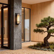 Contemporary outdoor wall mounted lighting installed beside entrance, casting warm ambient glow.