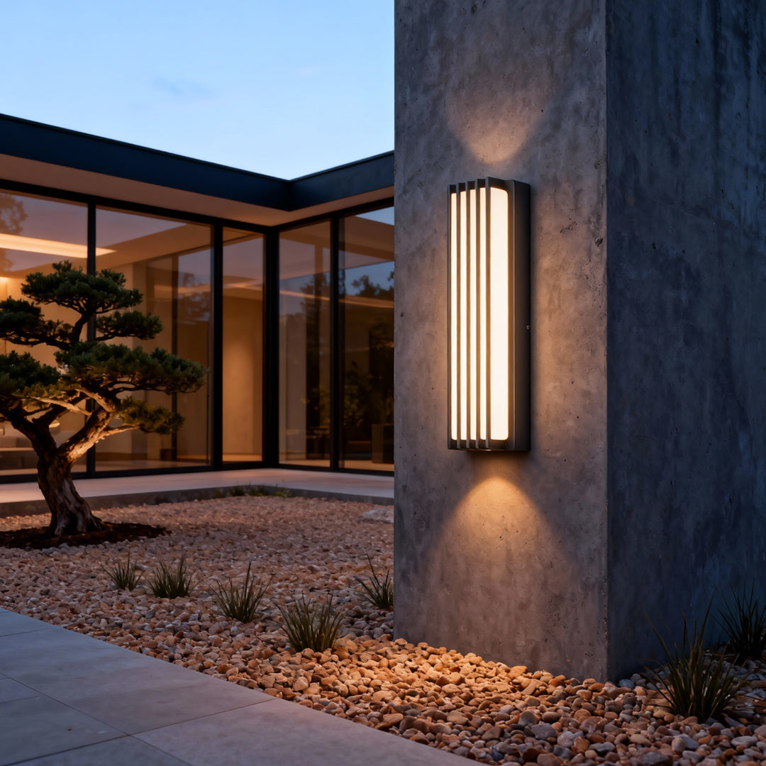 Outdoor wall-mounted linear lighting installed on a modern exterior wall, providing warm vertical illumination.