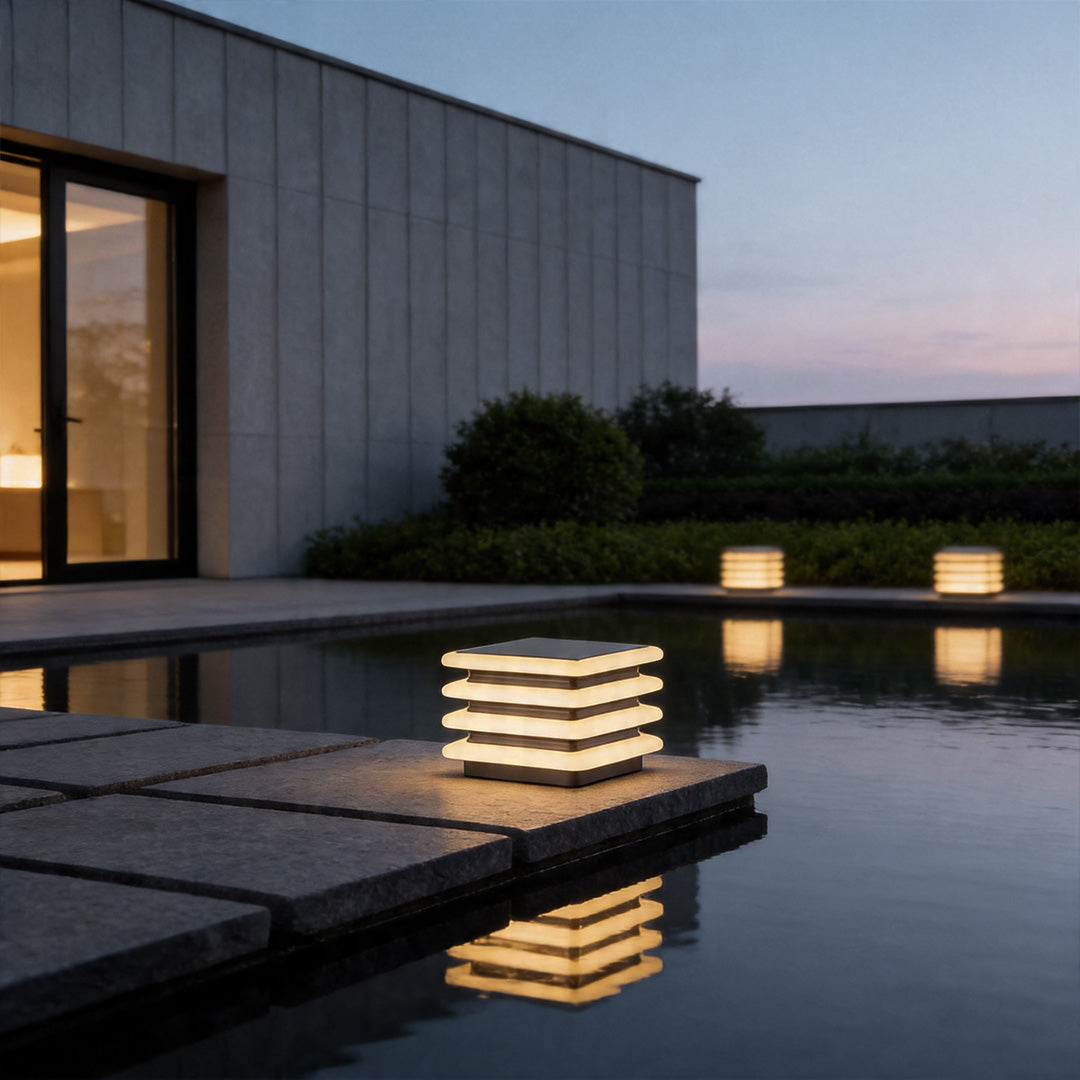 Outdoor wall pillar lights reflecting beside luxury pool with sleek contemporary exterior lighting style.