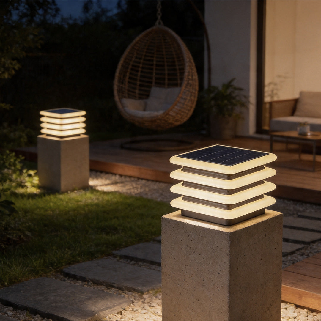 Outdoor wall pillar lights beside patio seating area with modern layered square lighting design.
