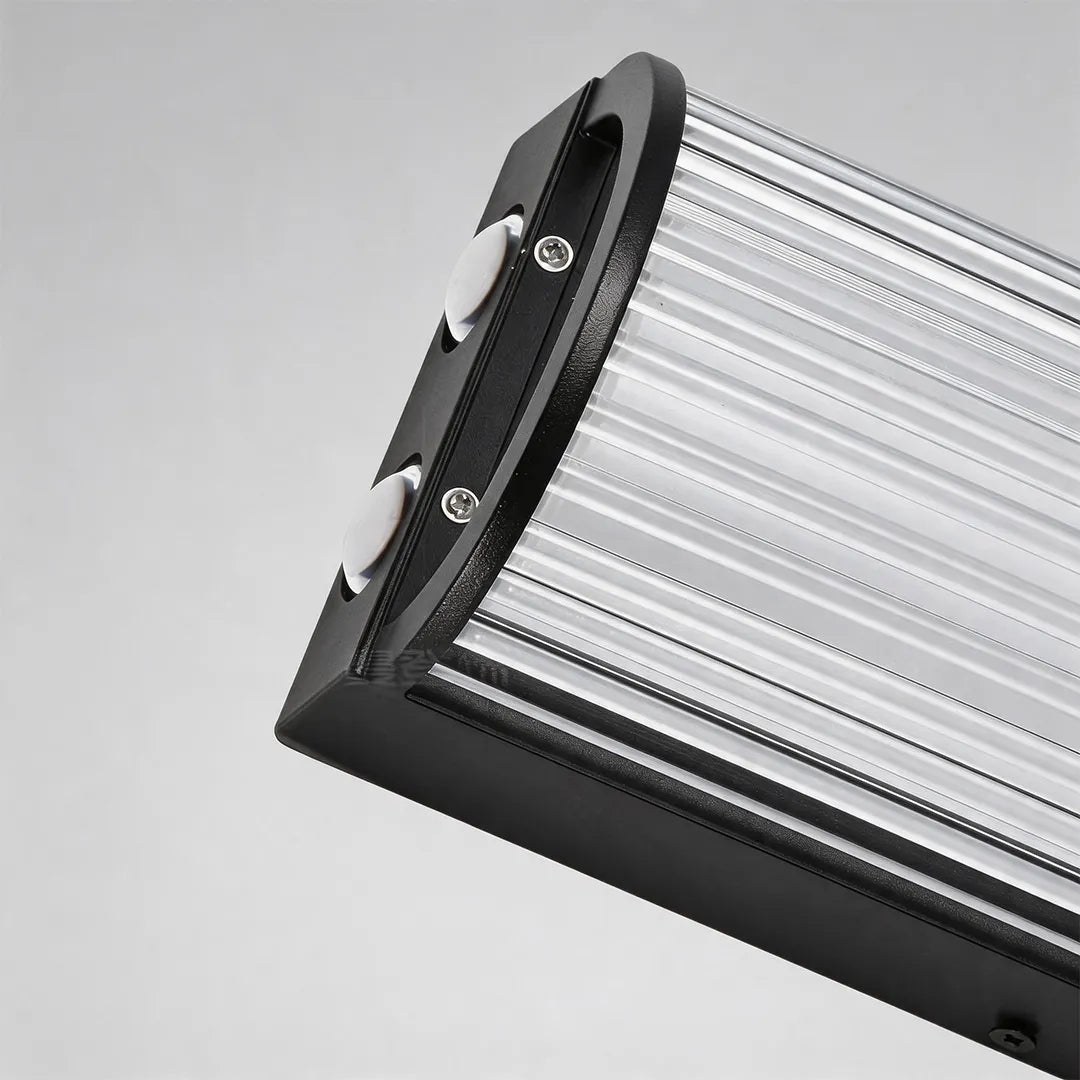 Outdoor wall sconce with black metal frame and ribbed glass diffuser detail