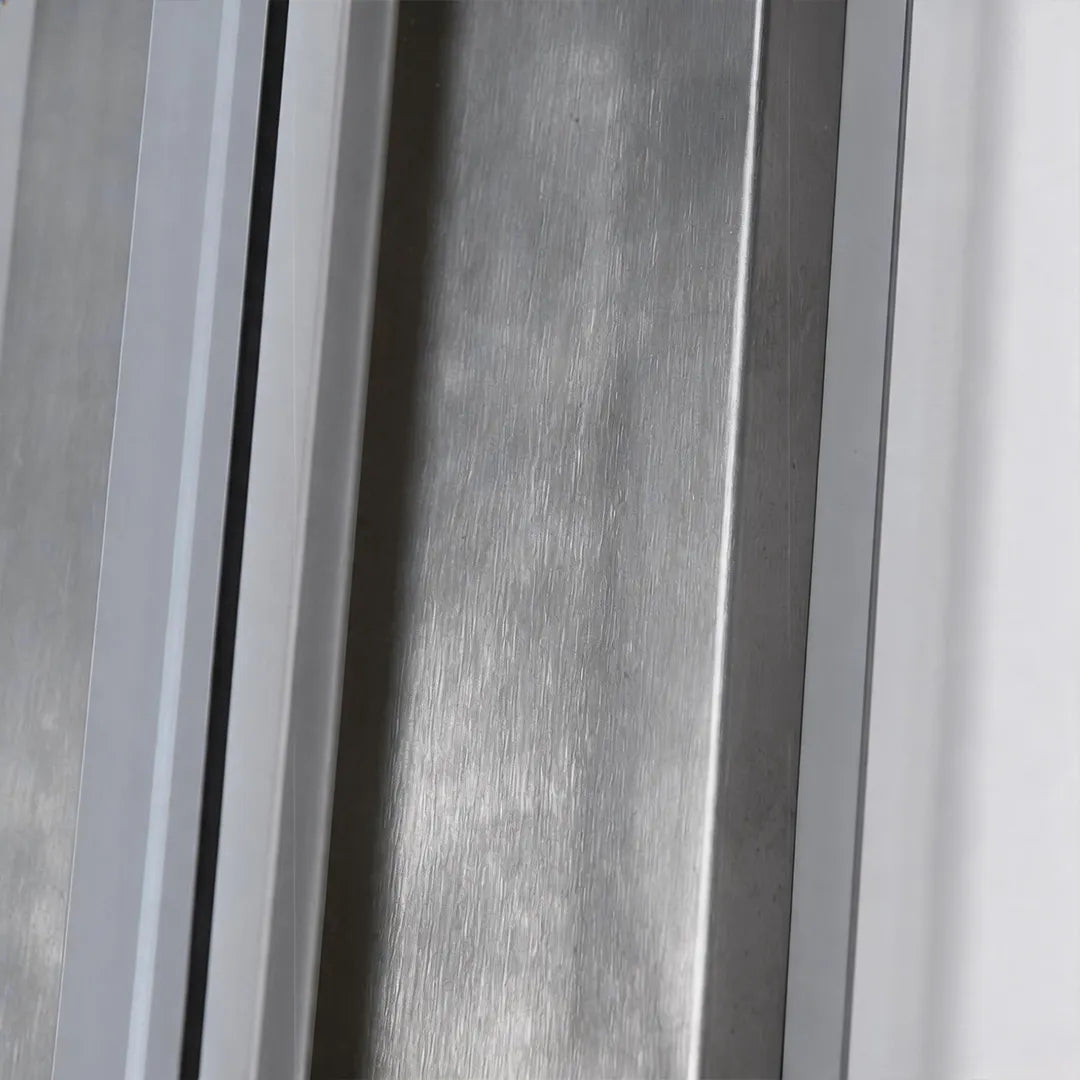 Outdoor wall sconce with brushed silver metal finish and clear glass shade