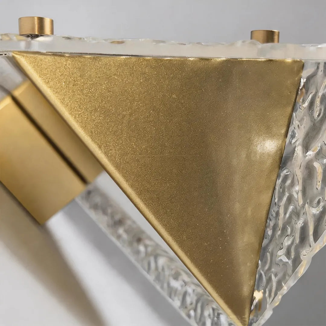 Outdoor wall sconce with brushed gold metal frame and textured glass detail