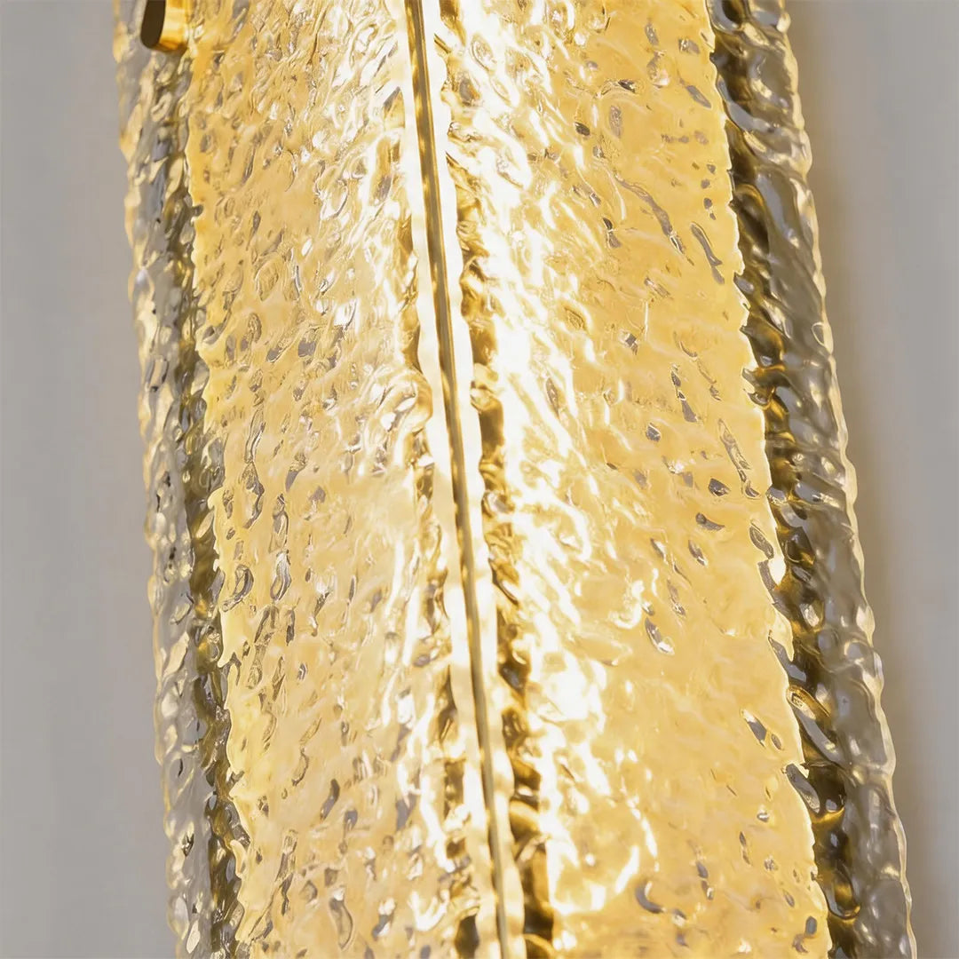 Outdoor wall sconce with illuminated textured glass and warm golden glow