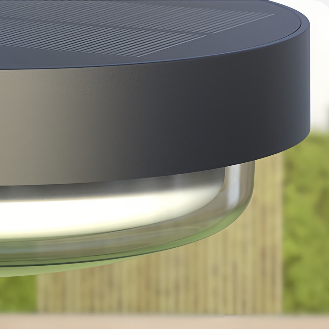 Close-up of modern outdoor wall sconce featuring matte black housing and glass diffuser.