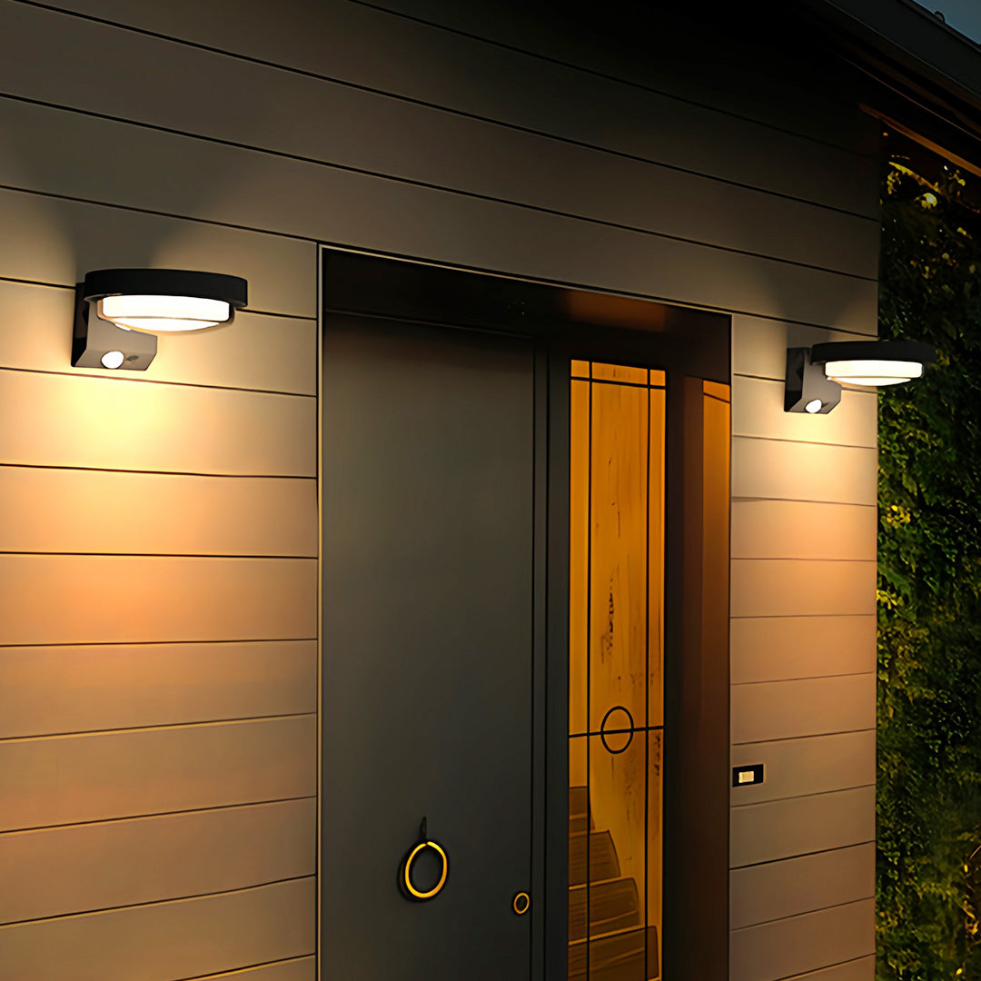 Modern outdoor wall sconces placed near front door providing warm entryway lighting.