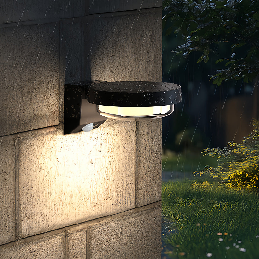 Contemporary outdoor wall sconce illuminating concrete wall with soft ambient glow.