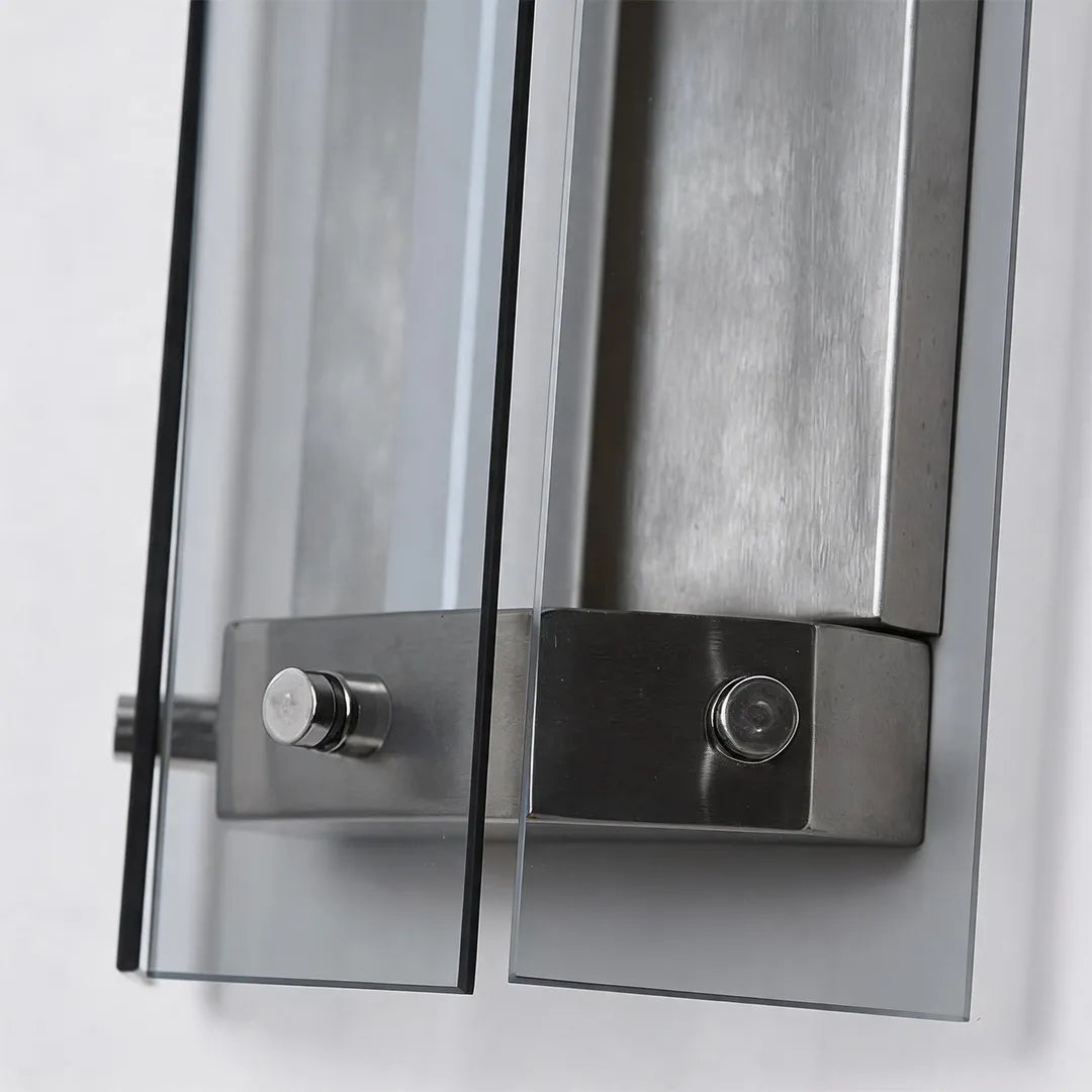Outdoor wall sconce with silver metal mounting bracket and glass detail