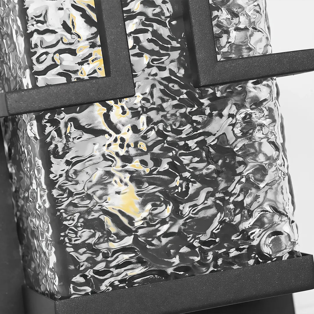 Outdoor wall sconce with textured clear glass and black metal frame detail